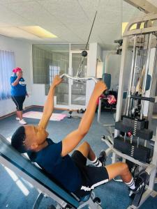 a man laying on a reformer in a gym at Signature Guesthouse in Ventersburg