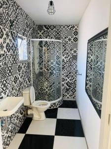 a bathroom with a toilet and black and white tiles at Signature Guesthouse in Ventersburg
