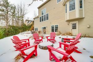a group of red chairs in the snow in front of a house at Screened Porch and Fire Pit Spacious Pocono Retreat in Pocono Pines