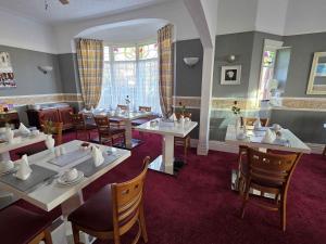 a dining room with tables and chairs and a window at Collingwood Hotel in Blackpool