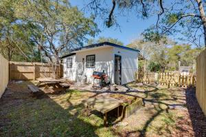 a small white shed with a picnic table and a fence at 6 Mi to St George Island Cozy Gulf Coast Retreat! in Eastpoint
