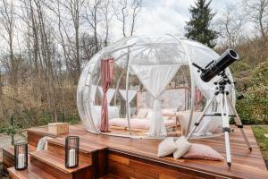 a bed in a dome tent with a camera on a deck at Il Cantico Experience in San Giacomo +6 photos