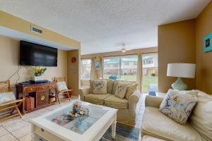 a living room with a couch and a tv at Surf Club B-9 in Dauphin Island