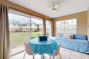 a bedroom with a table and a bed and a window at Surf Club B-9 in Dauphin Island +16 photos