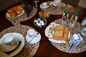 einen Holztisch mit Teller mit Speisen und Getränken in der Unterkunft La luna nel Cortile in Serradifalco + 15 Fotos