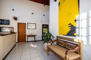 a waiting room with a bench and a painting on the wall at Pousada Maria Maria Búzios in Búzios