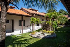 a house with palm trees in the yard at Pousada Maria Maria Búzios in Búzios