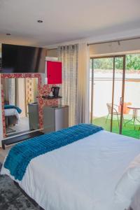 a bedroom with a large bed and a large window at Modern and Executive 2 Bedroom Townhouse in Bloemfontein