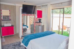 a bedroom with a bed and a tv on the wall at Modern and Executive 2 Bedroom Townhouse in Bloemfontein