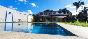una casa con piscina di fronte a una casa di Casa Brisas do Caldas! a Cruz