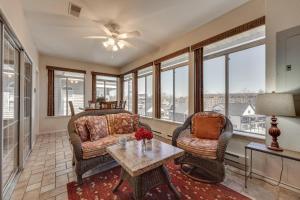 Una sala de estar con un sofá y sillas y ventanas. en Walk to Branson Strip Inviting Condo!, en Branson