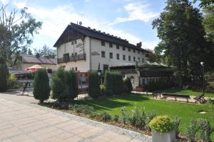 a large white building with a garden in front of it at Hotel Przepióreczka in Nałęczów