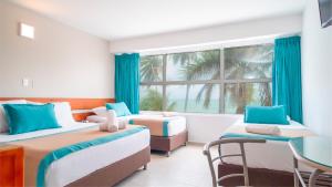 ein Schlafzimmer mit zwei Betten und einem Fenster in der Unterkunft Hotel Portobelo beach in San Andrés