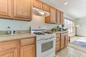 cocina con armarios de madera y horno de fogón blanco en Lakefront Home with Yard and Views in Cheboygan!, en High Banks
