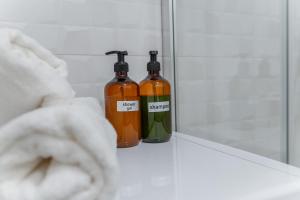 dos botellas de alcohol sentadas en un mostrador en un baño en Kriva Apartment 3 City Center Kosice, en Košice 13 fotos más