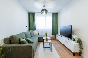 Una sala de estar con un sofá y un televisor de pantalla plana. en Kriva Apartment 3 City Center Kosice, en Košice
