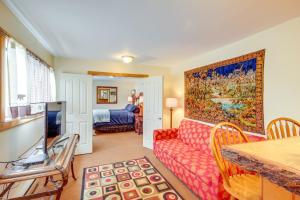 a living room with a red couch and a painting on the wall at Spacious Yellowstone River Retreat with Trails! in Emigrant