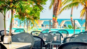 圣安德烈斯Hotel Portobelo beach的一间空的咖啡馆,里面摆放着桌椅,大海里