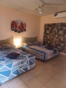 a bedroom with two beds and a lamp in it at LA DOLCE VITA FRANCOPHONE in Estelí