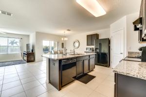 a large kitchen with a large island in the middle at 7 Mi to USTA Waterfront Tennis House with Yard! in Kissimmee
