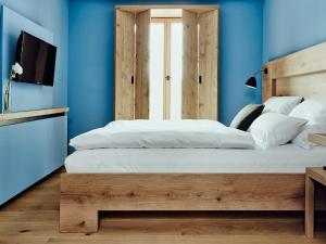 um quarto com uma cama grande e paredes azuis em Hotel Wedina an der Alster em Hamburgo