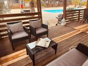 a wooden deck with chairs and a table and a pool at Casabella Turanj in Turanj