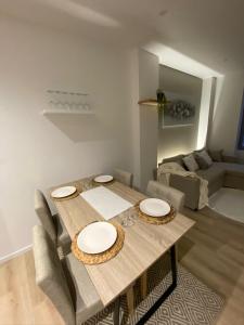 Una mesa de comedor con sillas y un sofá. en La Douce Escale Hyper centre, en Carcassonne