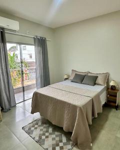 a bedroom with a bed and a large window at Apartamento Palmeira in Formosa