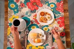 a table with two plates of food and a cup of coffee at Pousada Summer Beach by AFT in Porto De Galinhas