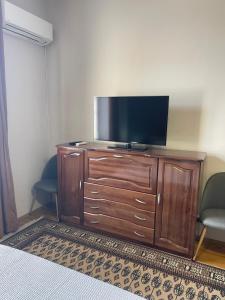TV de pantalla plana en una cómoda de madera en una habitación en Dara House, en Plovdiv