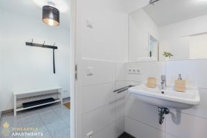 ein weißes Badezimmer mit Waschbecken und Dusche in der Unterkunft PINEAPPLE APARTMENTS - Zwinger XI - 64qm in Dresden