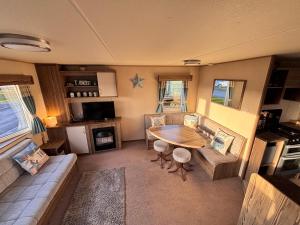 a living room with a table and a couch at Jay Valley 17 Thornwick Bay in Flamborough