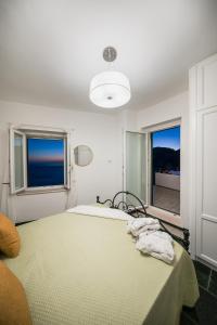 a bedroom with a bed and a large window at Villa Don Luigi in Furore