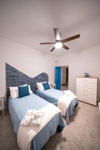 a bedroom with two beds and a ceiling fan at Villa Don Luigi in Furore