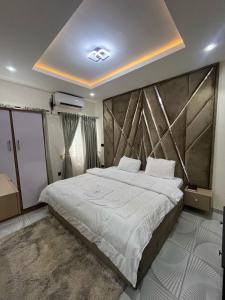 a bedroom with a large bed with a wooden headboard at Homespointe Apartment in Ibadan