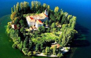 an island in the water with a house on it at Drnis Dream Apartment in Drniš