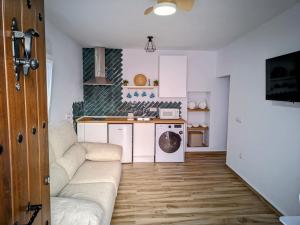 a living room with a couch and a kitchen at La Sala in Vejer de la Frontera