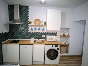 a kitchen with a washing machine and a sink at La Sala in Vejer de la Frontera