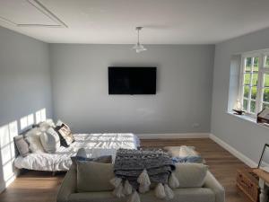 Una sala de estar con un sofá y un televisor. en Motts Lodge, en Kippings Cross
