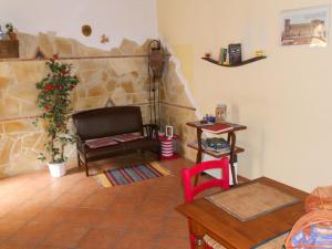 sala de estar con sofá y pared de piedra en B&B Le 2 Cantine, en Castroreale