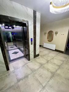 a lobby with a large glass door and a tile floor at Уютные апартаменты в новом жилом комплексе in Kostanay