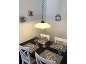 a dining room with a table and chairs and a lamp at Seestern Comfortable holiday residence in Wittdün +6 photos