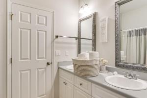 Un baño blanco con lavabo y espejo. en 10 Mi to Augusta Quiet Home with Patio and Yard!, en Graniteville 22 fotos más