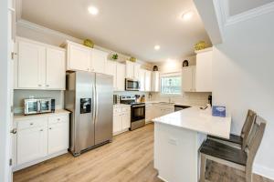 a kitchen with white cabinets and a stainless steel refrigerator at Family Beach Getaway in St Teresa Bike to Ocean! in Big Blackjack Landing