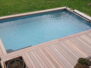 una vista dall'alto di una piscina con un ponte in legno di Alte Kaeserei Comfortable holiday residence a Kössern