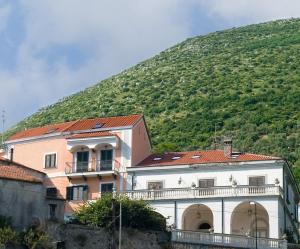 a building in front of a green hill at Farfalle E Gabbiani in Tramonti