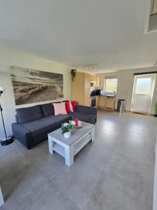 un soggiorno con un divano blu e un tavolo di De Mossel 147 a Bruinisse