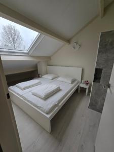 un letto bianco in una stanza con una finestra di De Mossel 147 a Bruinisse