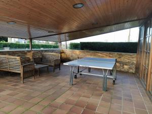 a patio with a ping pong table and benches at Apartamentos Rurales La Caramba in Lamuño