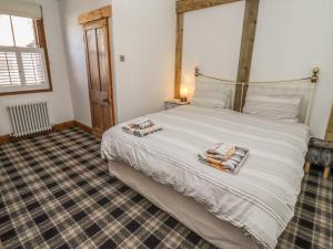 a bedroom with a large white bed with towels on it at Seafield Granary in Alnwick